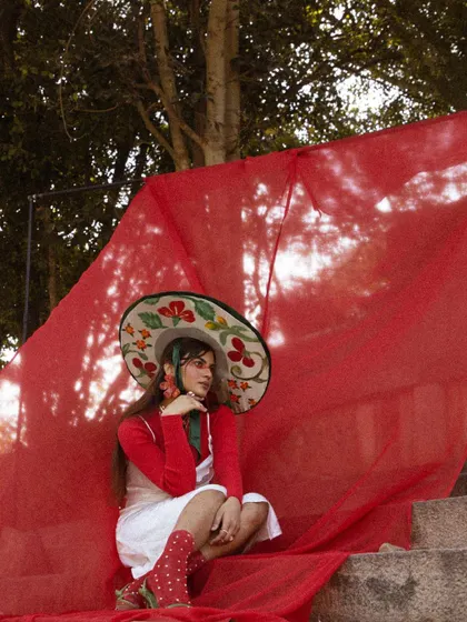 A seated pose from the 'LUNA' shoot, allowing the red fabric to pool around the model.