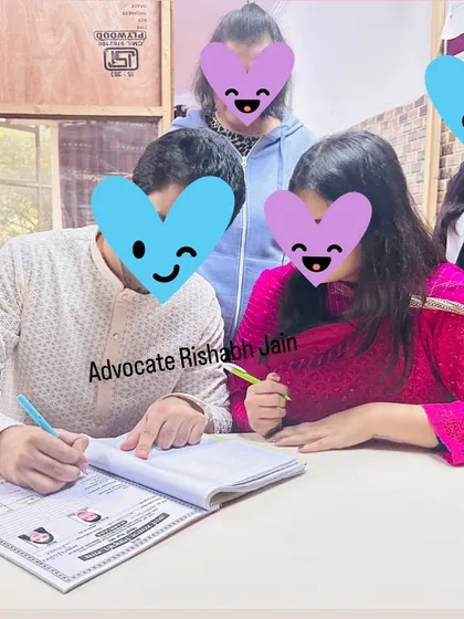A couple signs their marriage documents with family present, a perfect example of a love marriage with full support. I specialize in Delhi court marriages and related legal services.