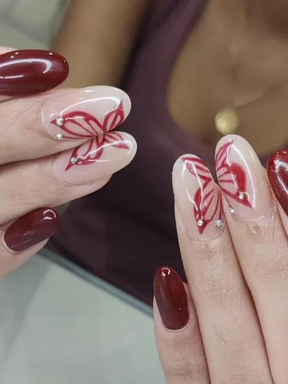 A close-up of our hand-painted butterfly wing nail art, detailed with tiny rhinestones for a touch of sparkle.