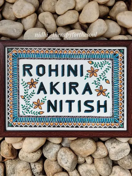 This nameplate was a gift for a loved one, featuring their names surrounded by simple, hand-painted flowers and leaves. The design is clean and elegant, with a beautiful border pattern.