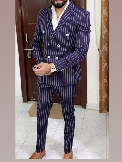 A bold statement with a navy pinstripe double-breasted suit. If you have a specific design in mind, I can create the same drape with my expert tailoring.