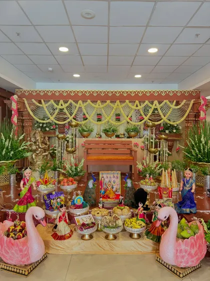 A full view of the traditional baby shower stage, featuring swan-shaped fruit baskets and dolls, adding a touch of whimsy to the classic decor.