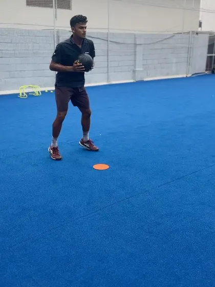 A tennis player holding a medicine ball, demonstrating the closed stance deceleration needed for stability after a lateral sprint. This is vital for maintaining balance and preparing for the next shot.