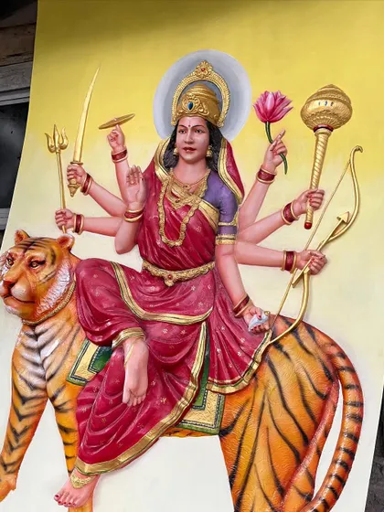 The finished Maa Durga sculpture, captured before installation. The bright yellow background makes the colors pop and highlights the 3D nature of the artwork.