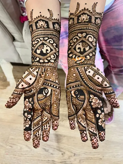 A mid-arm design featuring bold, contrasting patterns with elephants and lotuses.