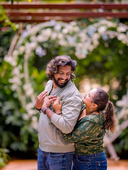 A fun and candid moment of a couple in a garden. The groom's playful expression and the bride's happy smile make this a very special and authentic shot.