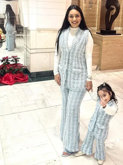 A chic winter look for a mother and daughter. We created these matching co-ord sets from a beautiful light blue tweed fabric, featuring a stylish sleeveless jacket and flared pants for a modern take on twinning.