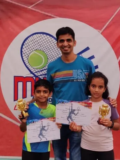 Avyaan and Ashvika with their coach and trophies.