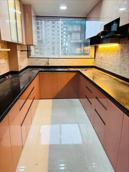 The large window at the end of the kitchen allows for plenty of natural light, which I've enhanced with reflective glossy surfaces.