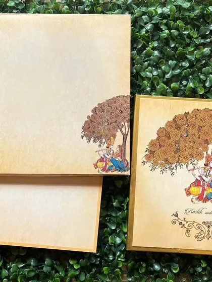 A beautiful invitation featuring a classic illustration of Radha and Krishna under a tree, perfect for a wedding rooted in tradition and love.