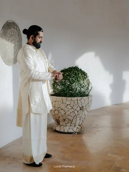 A candid shot of the groom checking his watch, a moment of quiet anticipation before the ceremony begins.