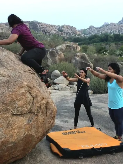 A beginner gets her first taste of bouldering with two spotters guiding her. Our workshops are focused on building a strong foundation of safety and technique.