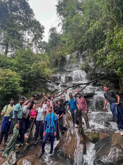 Our happy group posing in front of a multi-tiered waterfall on the Netravathi trek. It's a perfect spot to rest and take photos.