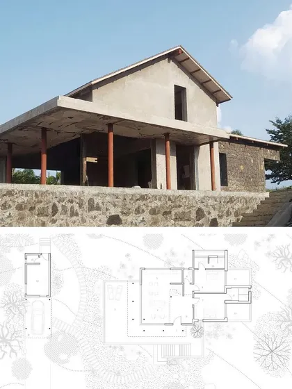 Ranch House under construction, with its architectural plan overlaid. This composite image connects the design on paper to the reality on site, showing the foundation of local basalt stone and the open veranda taking shape.