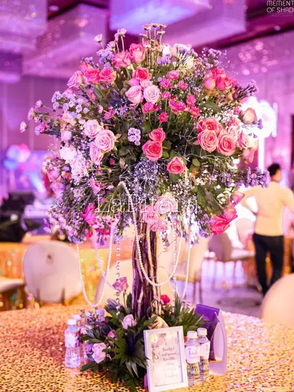 An exquisite floral centerpiece with pink roses and baby's breath, accented with pearls, for the enchanted garden party.