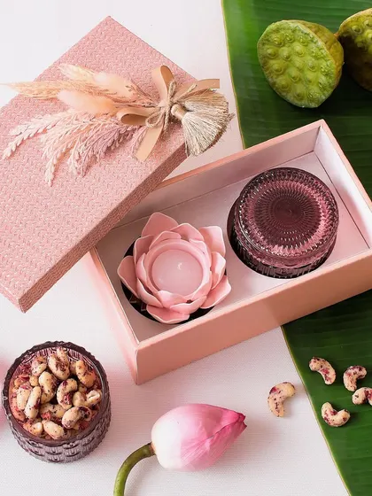 A lovely pink-themed Diwali hamper containing a flower candle and a jar of our signature cookies.