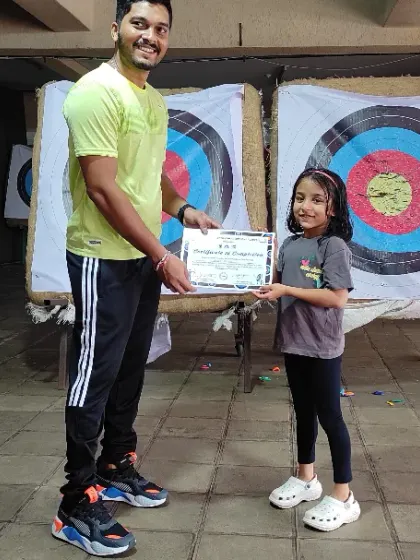 There's no better feeling than seeing a student's pride in their achievement. Here, I'm presenting a certificate of completion to a young archer after she finished her basic course.
