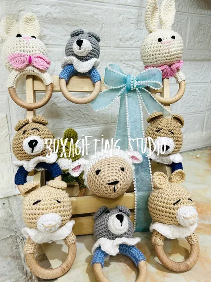 A collection of handmade crochet rattles, featuring bunnies, bears, and sheep. These soft, tactile toys are a wonderful addition to any newborn or baby shower gift.
