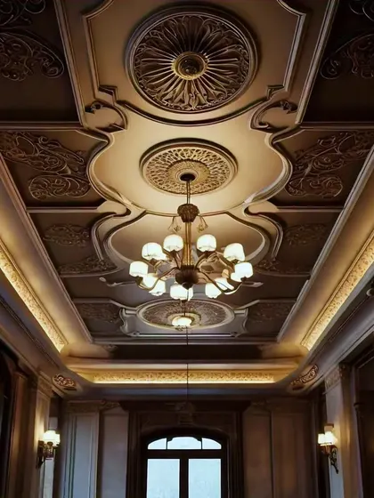 This is the ultimate in classic luxury. An ornate, coffered ceiling with intricate carvings, multiple medallions, and soft cove lighting that evokes the grandeur of a European palace.
