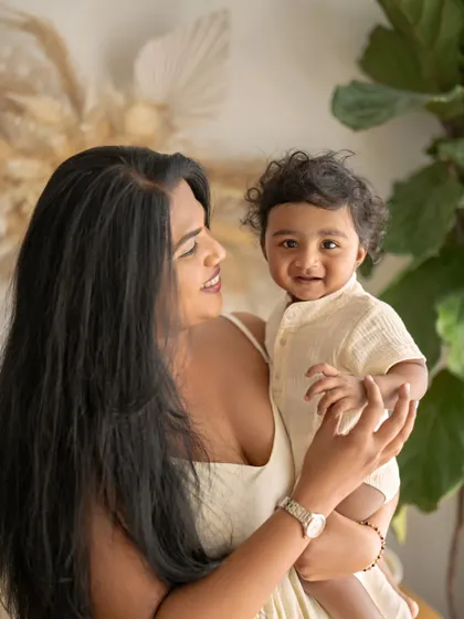 A mother holds her baby boy, both looking at each other with love. This simple, heartfelt portrait captures the deep connection between them.