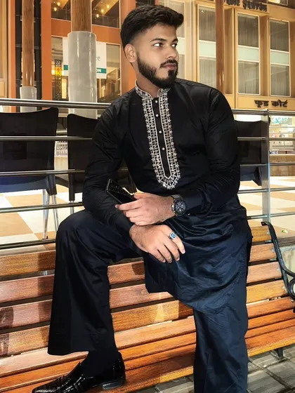 A full-length shot of the client in the black hand-embroidered kurta, showing how it pairs perfectly with black pathani pants.