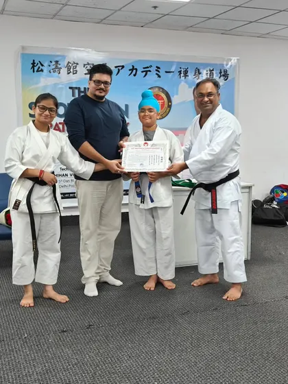 This student's hard work has paid off as she earns her blue belt. The presence of parents and senior instructors makes the belt examination ceremony a memorable occasion.