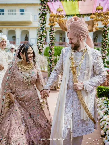 A beautiful, happy shot of the couple walking hand-in-hand after their pastel-themed Anand Karaj ceremony.