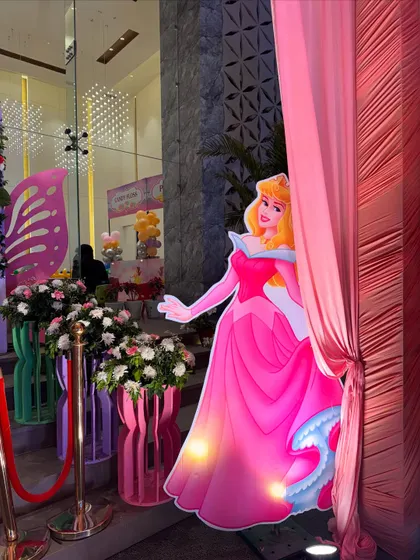 A life-sized Princess Aurora cutout stands at an entrance, welcoming guests to a royal celebration.
