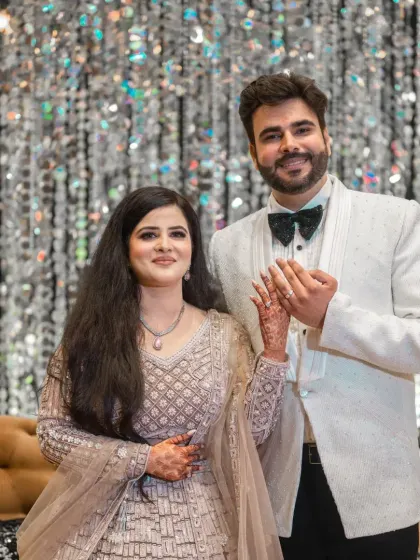 A beautiful portrait of the newly engaged couple, holding hands and smiling, with a glittering crystal backdrop.