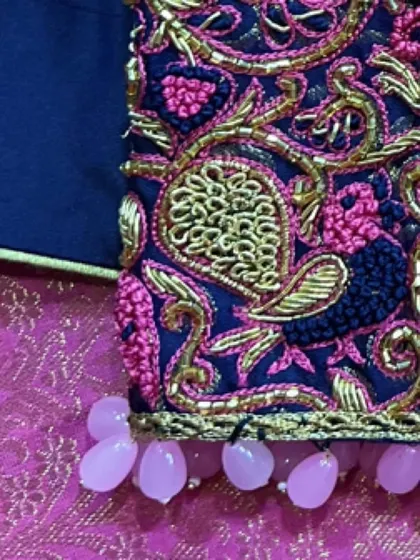 The finishing touch of pearl drop tassels on the sleeve of this navy blue blouse adds a touch of elegance and movement.
