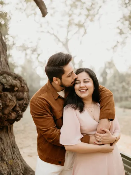 A warm and affectionate hug from behind, with the couple bathed in soft, natural light. This pose feels natural and loving, perfect for a candid couple photography session.