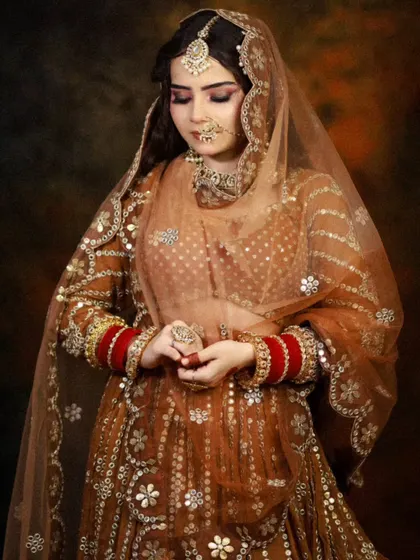 The full bridal look, showing the intricate details of the gota patti work on the lehenga, complemented by the makeup.