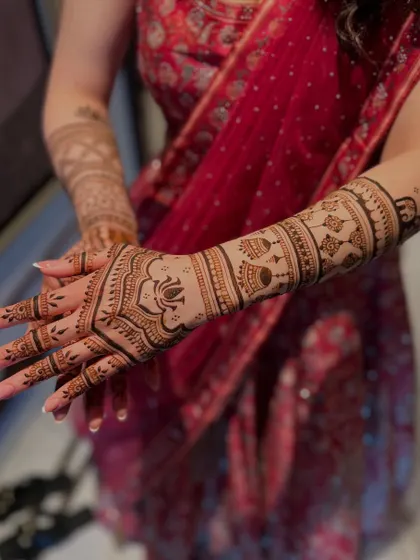 This semi-bridal design features a large lotus on the back of the hand, with kalash (ceremonial pot) motifs on the forearm. It's a very traditional and auspicious look.