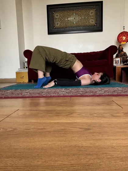Bridge pose with feet on a block, hips lifted and shoulders rooted.
