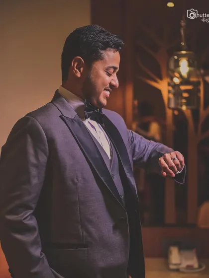 A candid shot of the groom, smiling as he checks the time. It’s these small, natural moments that add character to the wedding story.
