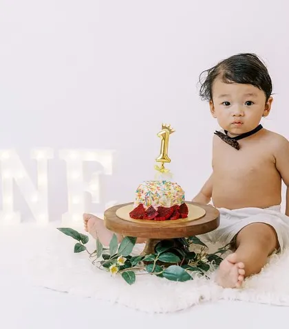 A sweet moment with a cupcake before the main cake smash. This little one is looking very serious about his first taste of birthday cake.