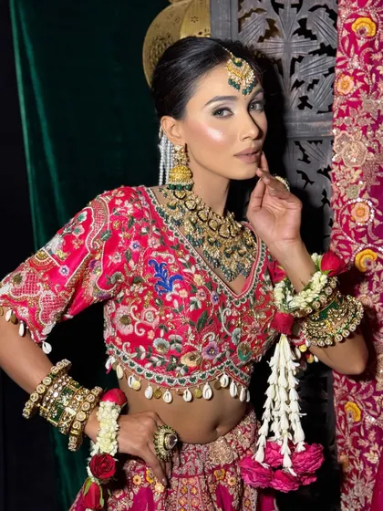 A confident pose from a model showcasing a complete bridal look. The makeup is bold and defined, perfect for photography and making a lasting impression.