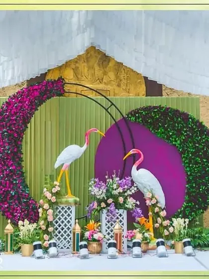 A whimsical and artistic photo backdrop featuring flamingo props and circular floral arrangements. This unique design is sure to be a conversation starter.