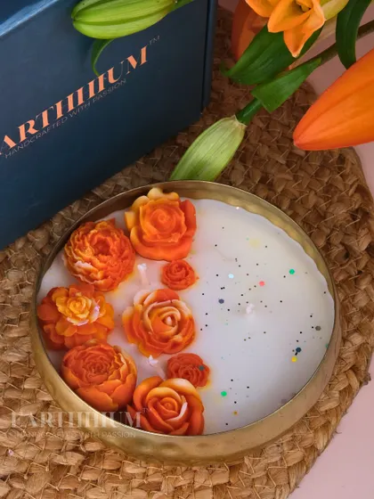 A warm, sunny Urli candle featuring beautiful orange roses. The glitter accents add a subtle sparkle, making it perfect for celebrations and festive decor.