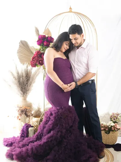 Both partners gazing lovingly at the baby bump. This pose is a beautiful way to show the shared focus and love for your soon-to-arrive little one.