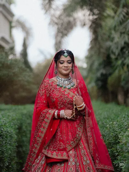 A quiet, contemplative portrait of the bride in her stunning red lehenga before the ceremony begins.
