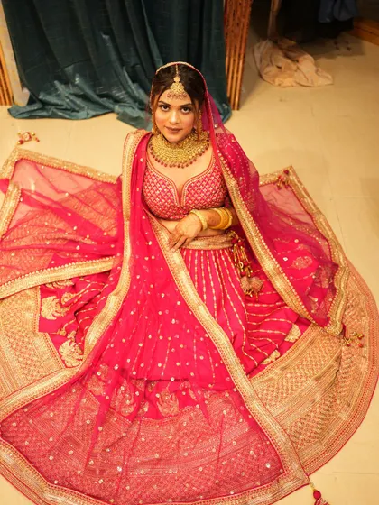 Another angle of the beautiful rani pink banarsi-style lehenga. The way the skirt is spread out shows the volume and richness of the fabric and design.