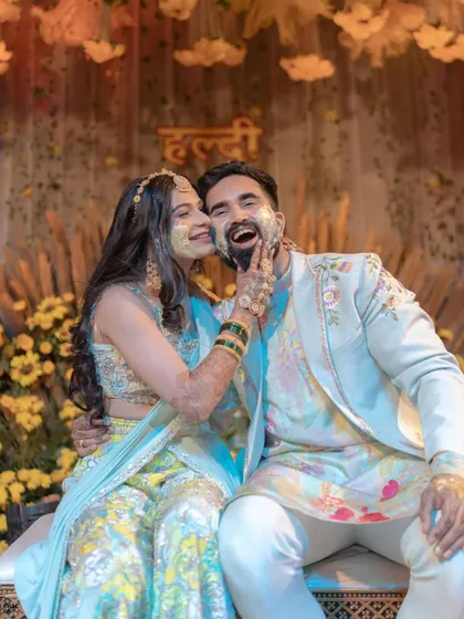 A fun and candid moment from a Haldi ceremony, with the bride wearing our delicate floral shela over her lehenga. It adds a layer of tradition and beauty to the celebration.
