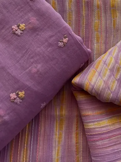 This purple Mul Chanderi set includes one fabric with delicate floral butis and a coordinating striped fabric, perfect for a complete suit set.