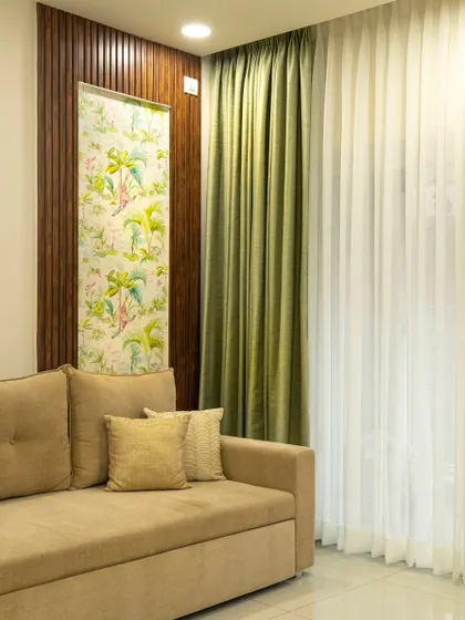 This living room from 'Bohemian Bliss' uses a sofa-cum-bed for flexibility. The tropical wallpaper panel framed by dark wood fluting adds a pop of pattern and defines the seating area.