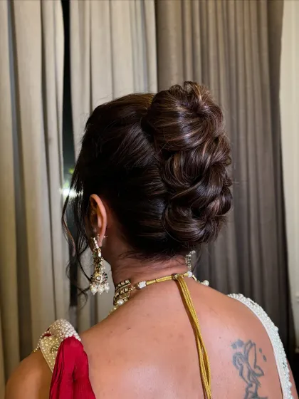 A close-up of the textured high bun, showing the intricate weaving of the hair.
