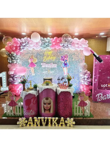 A glamorous Barbie themed birthday party with a pink sequin backdrop and doll-themed props.