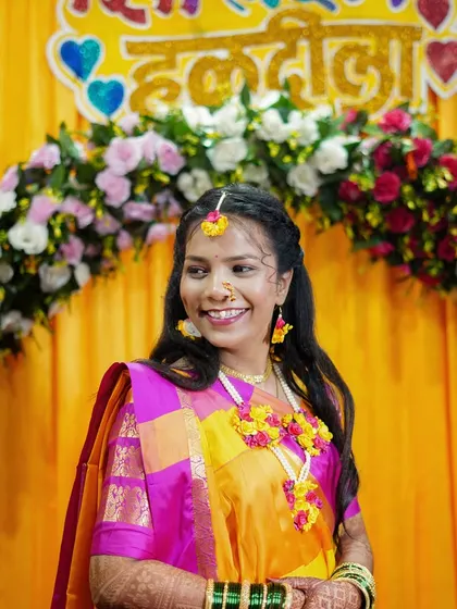 The bride looking away with a gentle smile during her Haldi ceremony.