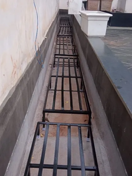 A series of stands placed end-to-end to create a long, continuous platform for plants in a narrow terrace section.