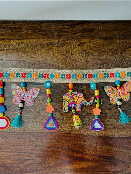 A full-length shot of the 'Bageecha' Toran. The alternating animal and butterfly motifs create a playful rhythm, and it's all 100% plastic-free.